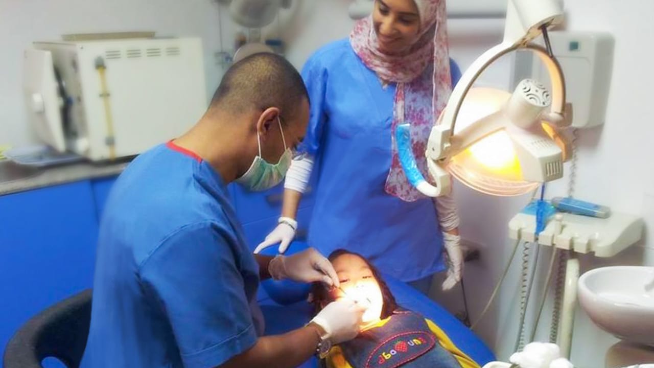 elite-smile-clinics-elgazaer-8 Dr. Ahmed Atteya performing procedure in operating room at Elite Smile Clinics Elgazaer branch - Your trusted dental clinic in Cairo