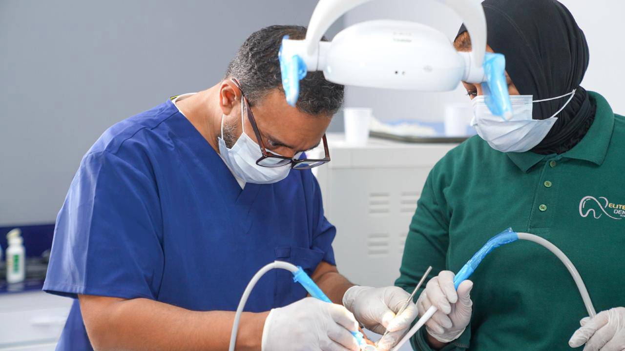elite-smile-clinics-new-cairo-11 Dr. Ahmed Atteya performing procedure in operating room at Elite Smile Clinics New Cairo