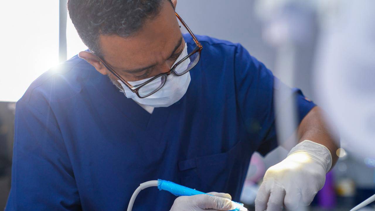 elite-smile-clinics-new-cairo-14 Dr. Ahmed Atteya performing procedure in operating room at Elite Smile Clinics New Cairo